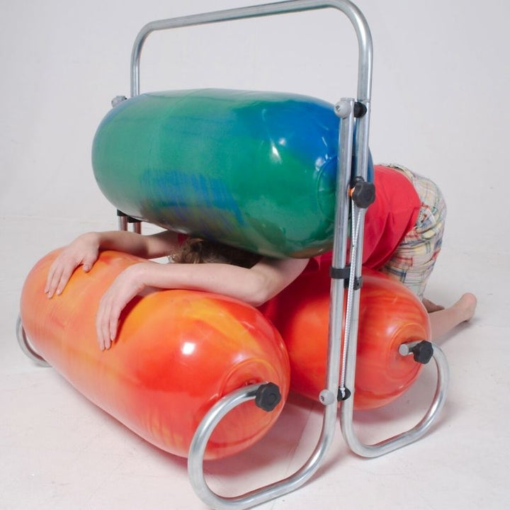 Child squeezing through the TFH Squeeze Machine inflatable rollers, experiencing adjustable deep pressure therapy for sensory regulation and body awareness