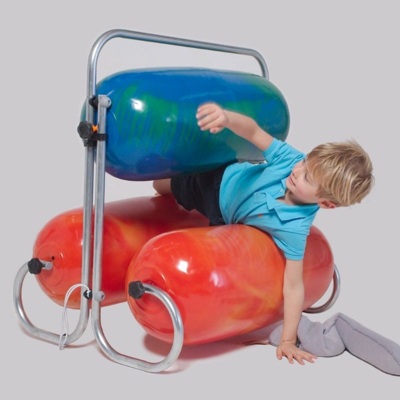 Toddler squeezing through the TFH Squeeze Machine bumpers, demonstrating deep touch pressure proprioceptive input for calm and self-regulation
