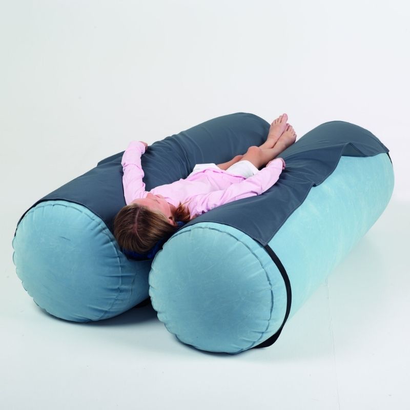 Person using TFH Mega Squish Squash Tubes lying between two inflatable velvet rollers demonstrating deep pressure sensory therapy for proprioceptive input and self-regulation