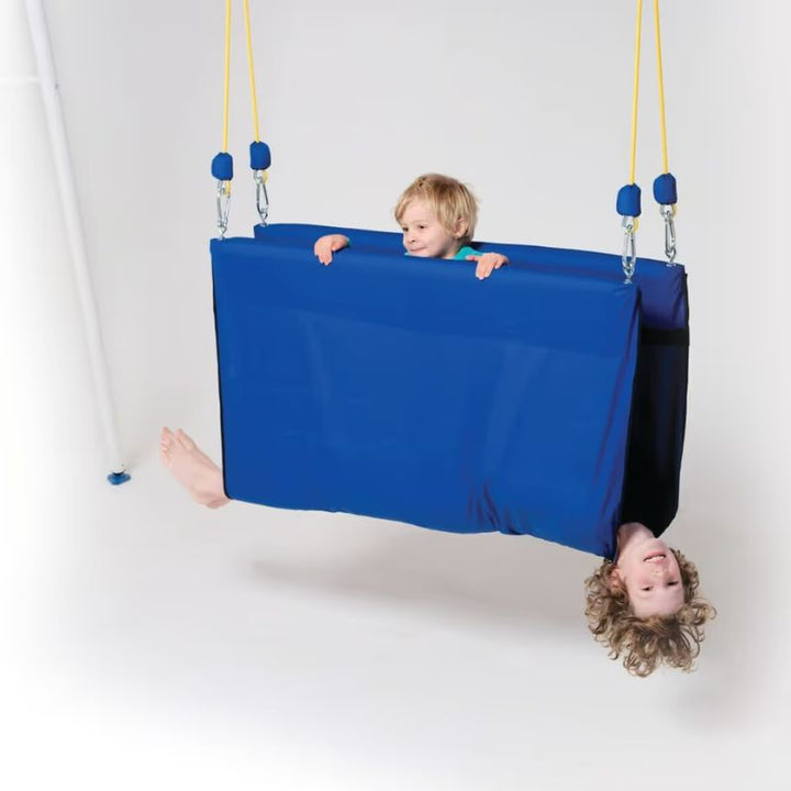 Child playing upside down in the TFH Deluxe Taco Swing, a full-body compression sensory swing that supports vestibular and proprioceptive input