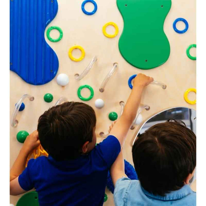 Two children exploring the ridged and looped textures on the TFH Tranquil Textured Wall, a tactile sensory panel supporting shared touch based play