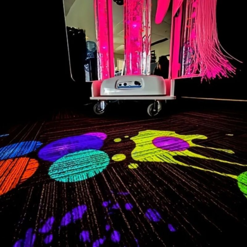 TFH Vecta Budii mobile sensory cart glowing pink as its Omi Budii projector casts a colourful interactive paint-splash scene across the floor
