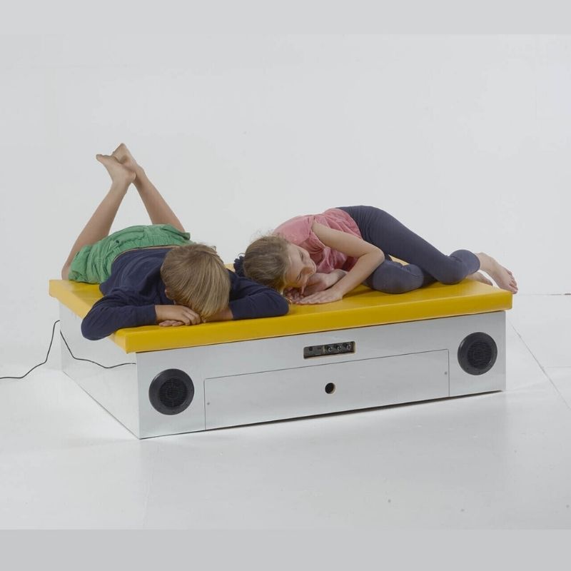 Two children using the TFH Vibroacoustic Platform with Foam Pad demonstrating full-body vibroacoustic sensory therapy and sound vibration input