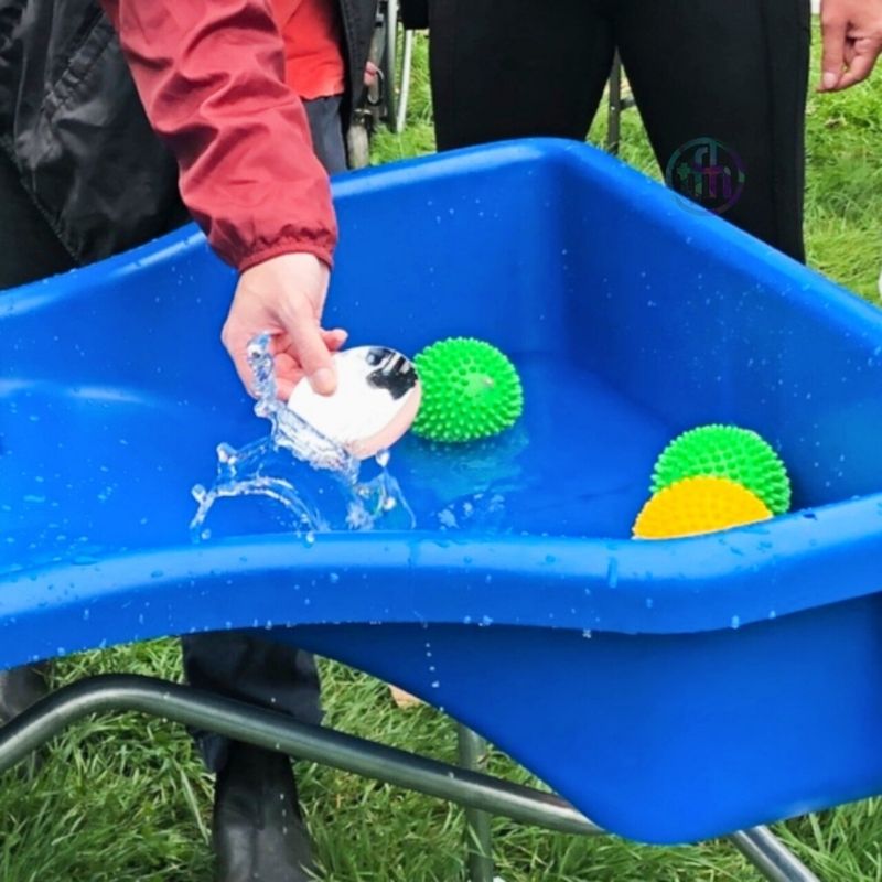 Close-up of the TFH Wheelchair Accessible Sand and Water Table in use with water and coloured balls, demonstrating tactile sensory play and fine motor activity