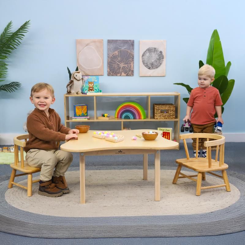Two toddlers enjoying the Whitney Brothers Toddler Flower Table and Chair Set in a bright playroom, a wooden toddler table and chairs set for daycare and home play