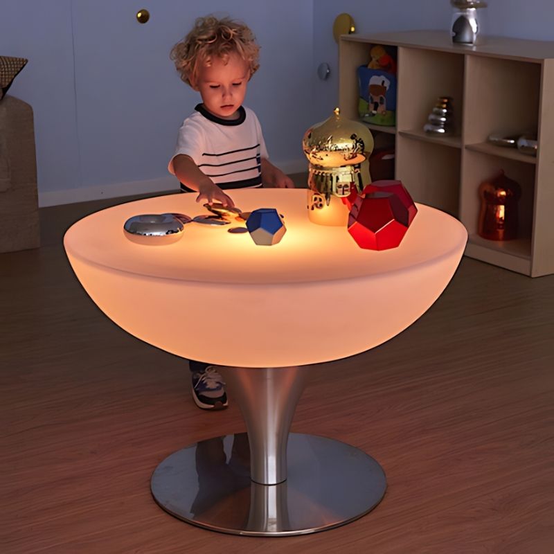 TTS Colour Changing Glow Table in warm amber light with a child engaged in open-ended sensory exploration, demonstrating the adjustable LED mood settings