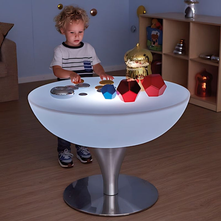Young child exploring tactile objects on the TTS Colour Changing Glow Table illuminated in white, a sensory light table for early years classrooms and therapy rooms