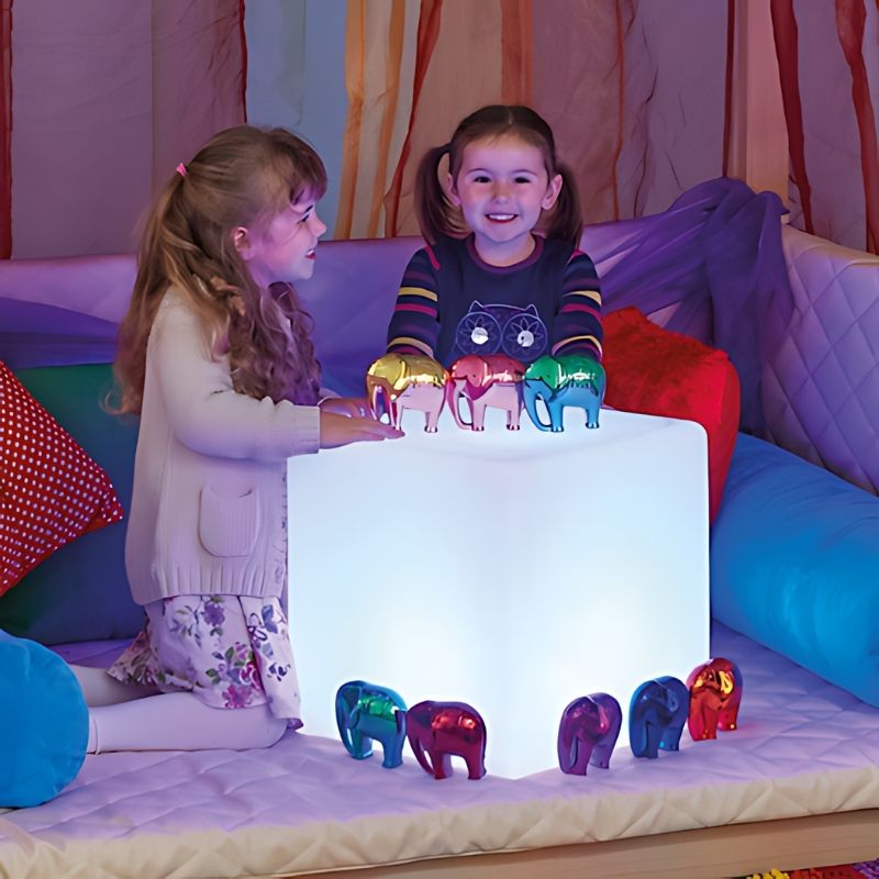 TTS Colour Changing Light Up Cube glowing in use during collaborative sensory play, with two children engaging with the LED light in a sensory room setting
