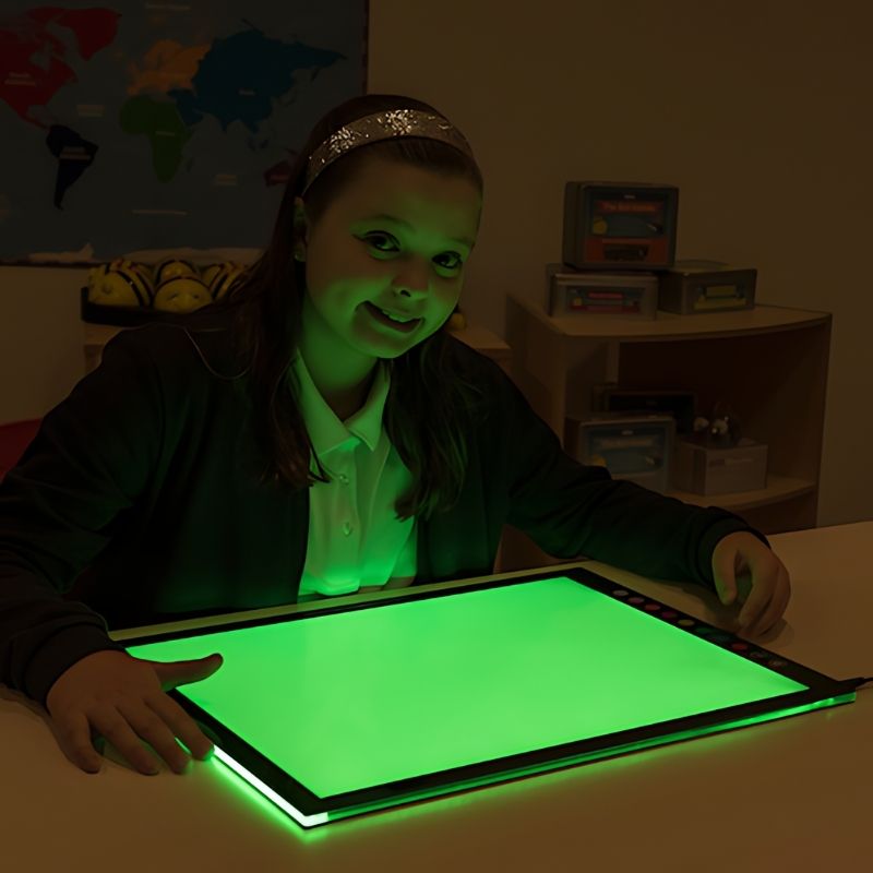 Girl using the TTS Colour Changing Light Panel in green light mode during indoor sensory and STEAM learning play