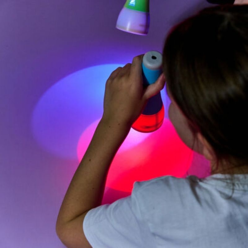 Child's hand holding a TTS Colour Changing Easi-Torch, demonstrating the ergonomic grip design and fine motor engagement during sensory play