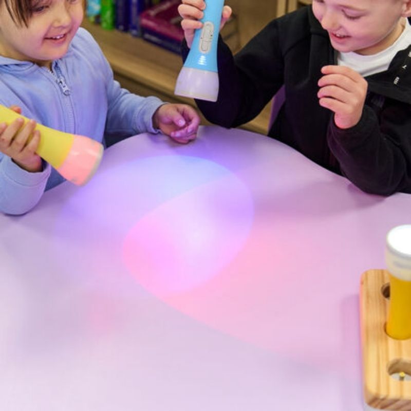 Two children playing with TTS Colour Changing Easi-Torches in pastel LED colours, a handheld sensory light toy for early years and classroom exploration