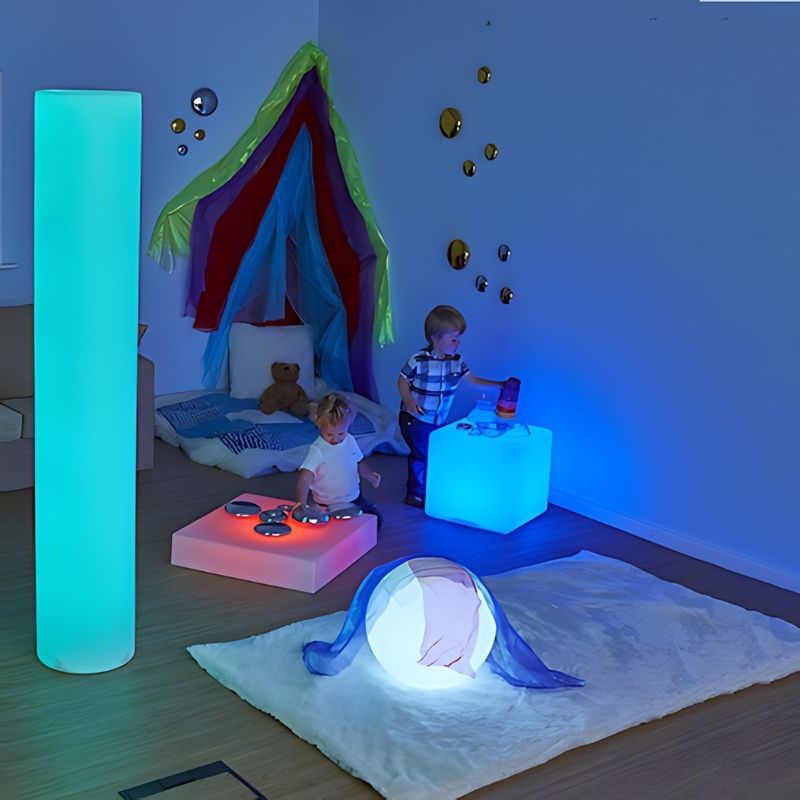 TTS Giant Sensory Glow Cylinder Tube glowing blue in a play setting, showing the LED colour-changing visual sensory light in use