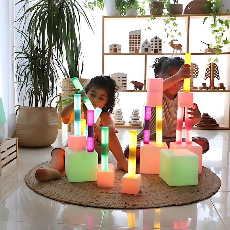 Children collaborating with TTS rechargeable glow cylinders in an early years setting, supporting group sensory play and communication development