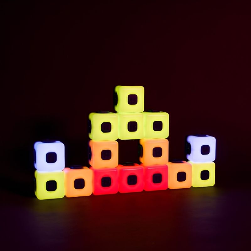 TTS Glow Sequencing Cubes arranged in a stepped pyramid pattern against a dark background, displaying a warm colour gradient sequence from yellow-green at the top through orange to red at the base