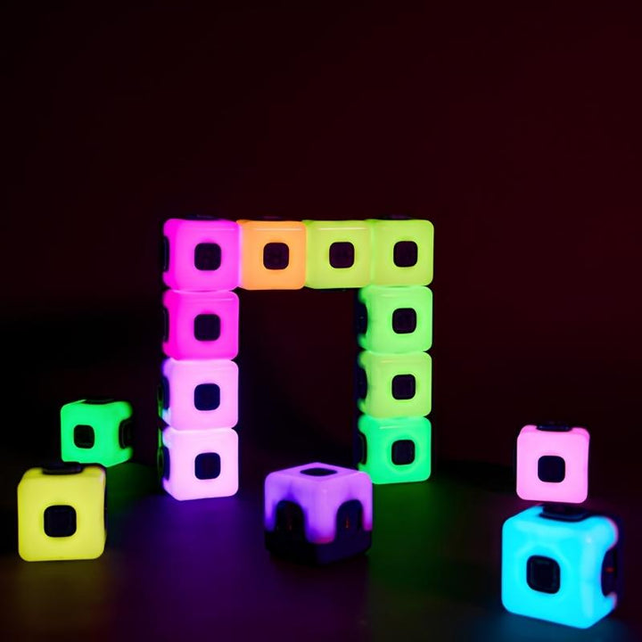 TTS Glow Sequencing Cubes arranged in a glowing square frame pattern against a dark background, showing magnetic connection and multi-colour sequencing in pink, green, purple, blue and yellow
