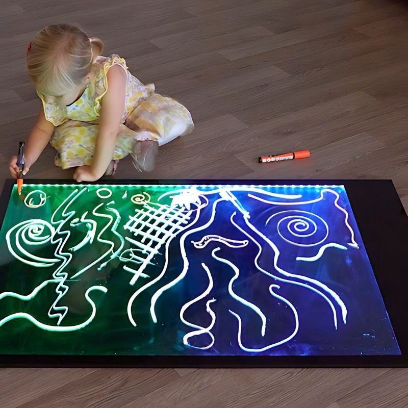 Child drawing on the TTS Giant Illuminated Mark Making Board, demonstrating pre-writing and mark making skills on the large rechargeable light board