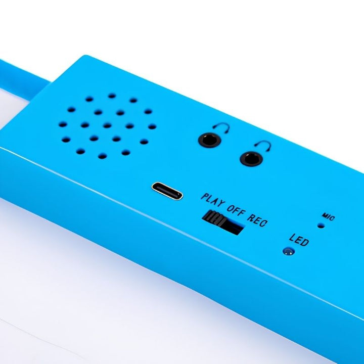 Close-up of the TTS Interactive Talking Mat blue audio unit showing dual headphone sockets, USB-C charging port, speaker, PLAY-OFF-REC switch, microphone and LED indicator