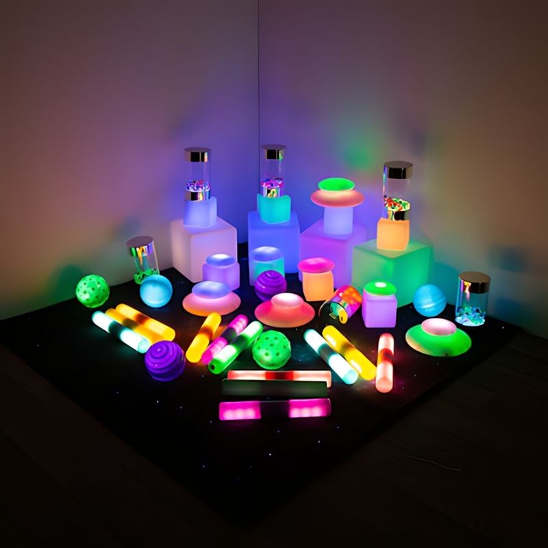 TTS Sensory Light Up Glow Collection arranged in a corner display, showing the full 48-piece LED kit set up as a sensory room light-play environment