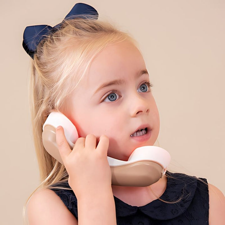 Close up of child engaged with TTS Light Up Phone handset, demonstrating button interaction and sensory stimulation for early years communication