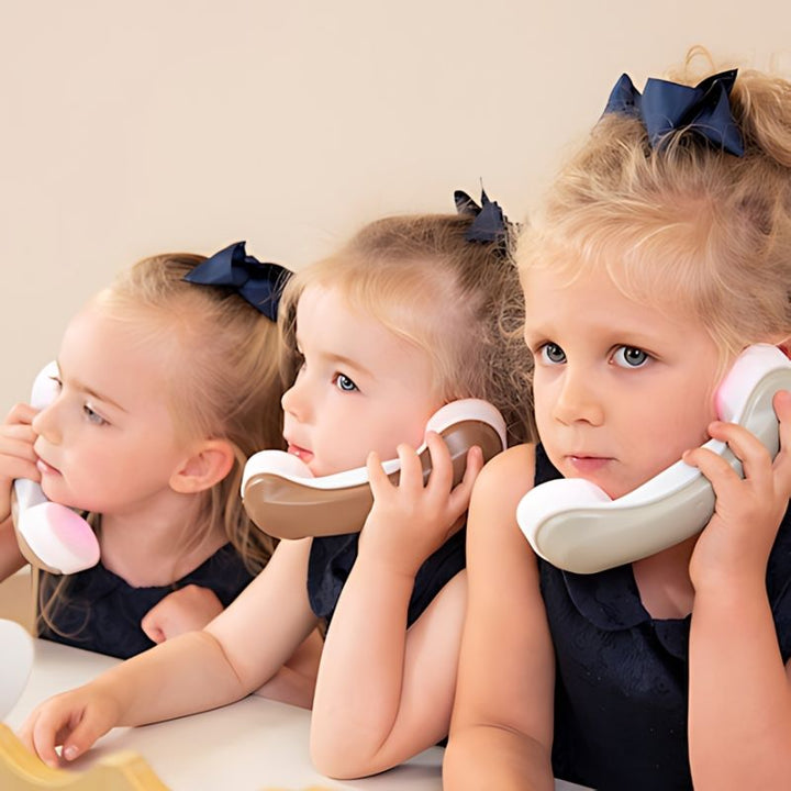 Three children using TTS Light Up Phones during role play, supporting communication skills and turn-taking in an early years setting