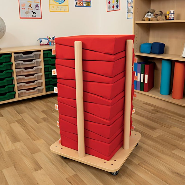 TTS Maxi Wedge posture cushion in red, shown in an indoor classroom setting demonstrating ergonomic floor seating for children