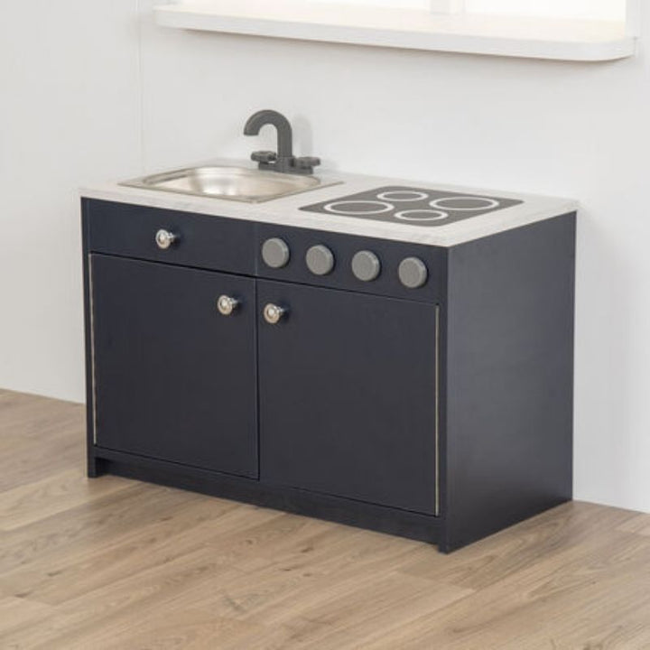 Child engaged in imaginative role play at the TTS Modern Living Sink and Hob Unit, exploring pretend kitchen routines in an early years classroom setting