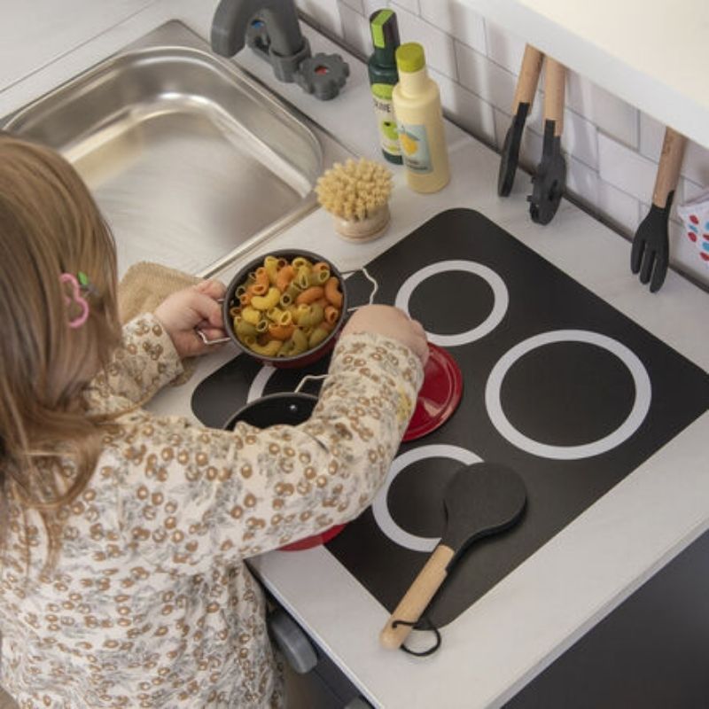 Young child playing at the TTS Modern Living navy play kitchen sink unit, developing fine motor skills and communication through home corner role play