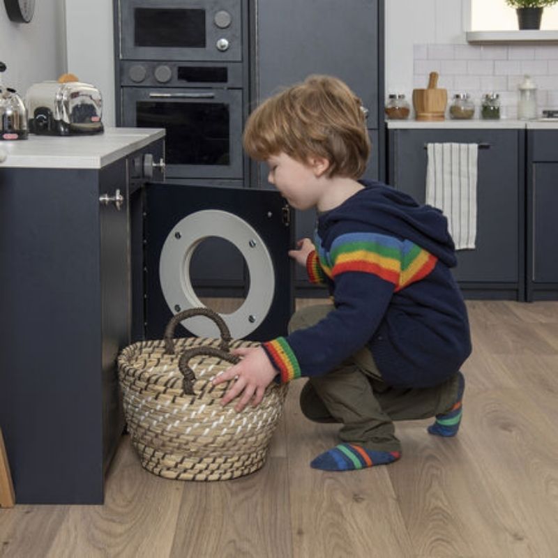 Child engaged in pretend play with the TTS Modern Living Washing Machine, a role play toy supporting fine motor skills and social development
