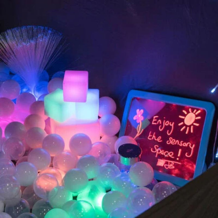 Close-up inside the TTS Pop-Up Sensory Space with glowing ball pit, light-up cubes, fibre optic lamp and LED message board for multi-sensory exploration