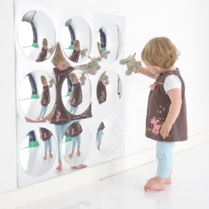 Child actively playing and exploring reflections with the TTS Sensory Bubble Mirror mounted on a wall, a shatterproof visual sensory tool for classrooms and sensory rooms