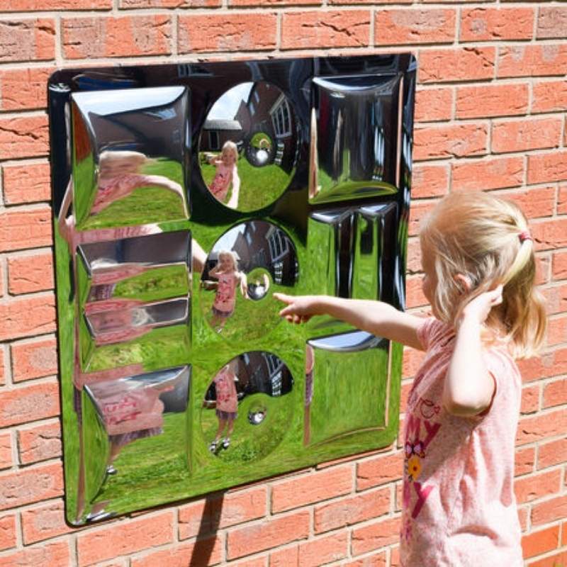 Child actively engaging with the TTS Sensory Bubble Shapes Mirror on a wall, exploring visual reflections through shatterproof convex bubble domes