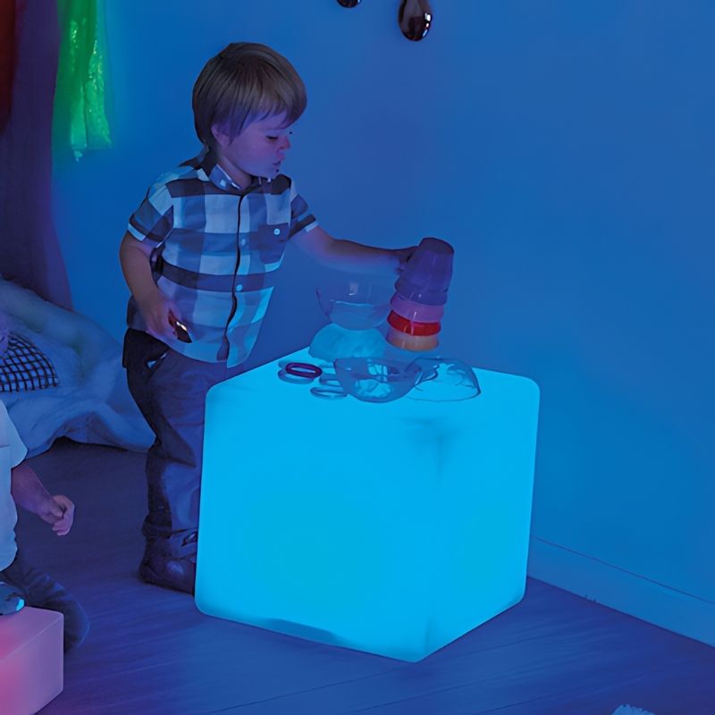 Child actively playing with the TTS Colour Changing Sensory Light Cube in blue LED mode, a visual sensory tool for therapy rooms and classrooms