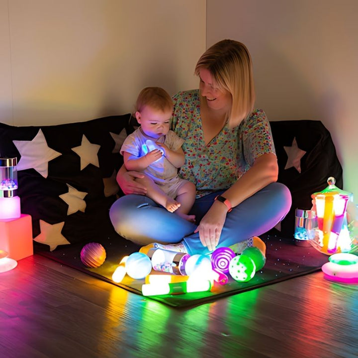 TTS Sensory Light Up Glow Collection shown with a parent and child exploring glow toys together, demonstrating light-up sensory play