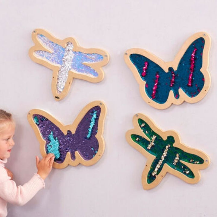 Child actively playing with the TTS Mark Making Sequin Butterflies and Dragonflies sensory wall panel, swiping the flip sequins to build fine motor skills and hand-eye coordination
