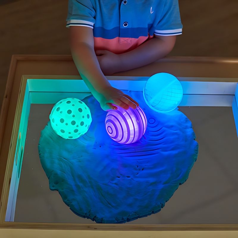 TTS rechargeable tactile glow spheres showing three distinct raised silicone pattern designs, sensory balls for fine motor skills and cause and effect play