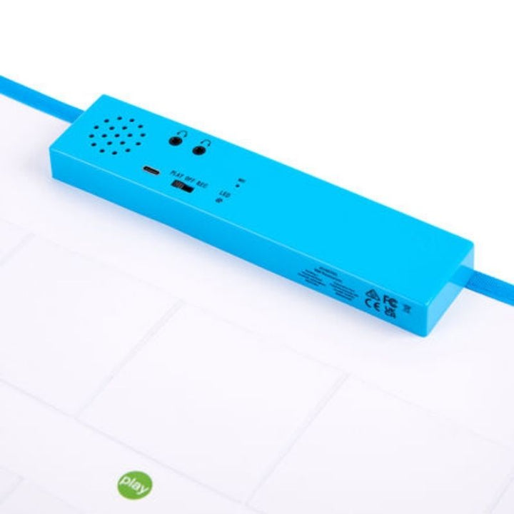 Angled view of the TTS Interactive Talking Mat with the rechargeable blue recording unit attached at the top and recordable pockets below, showing the mat ready for classroom use