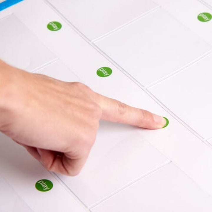 Close-up of a hand pressing the green play button on the TTS Interactive Talking Mat, demonstrating the simple one-touch voice playback feature for classroom use