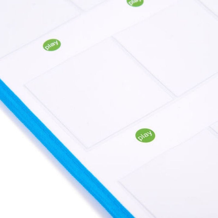 Angled detail of the TTS Interactive Talking Mat showing the clear card pockets with green play buttons and durable blue fabric border used in schools and therapy rooms
