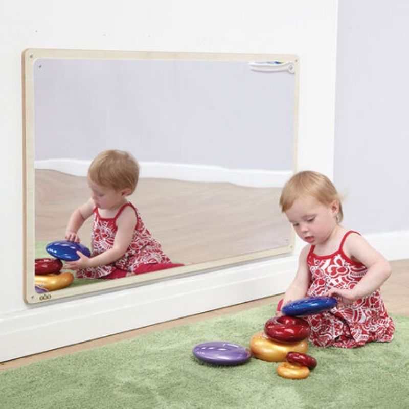 TTS Wooden Framed Toddler Mirror with a young girl sitting in front of it, exploring her reflection during sensory play in an early years environment