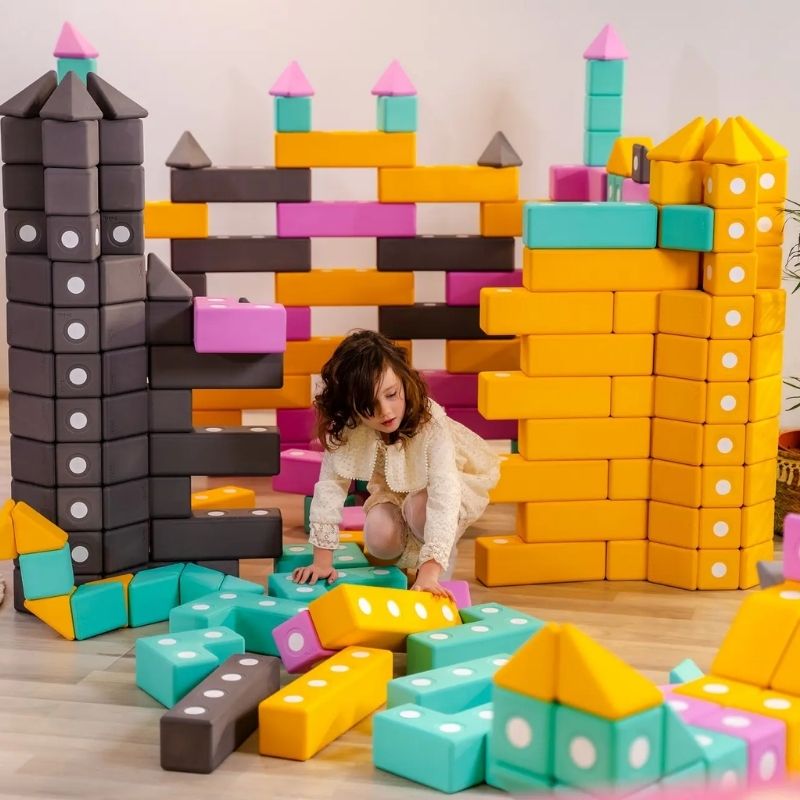 Child actively building with TUKI Big Magnetic Foam Blocks Smart 340, demonstrating large-format sensory building blocks for motor development and creative play