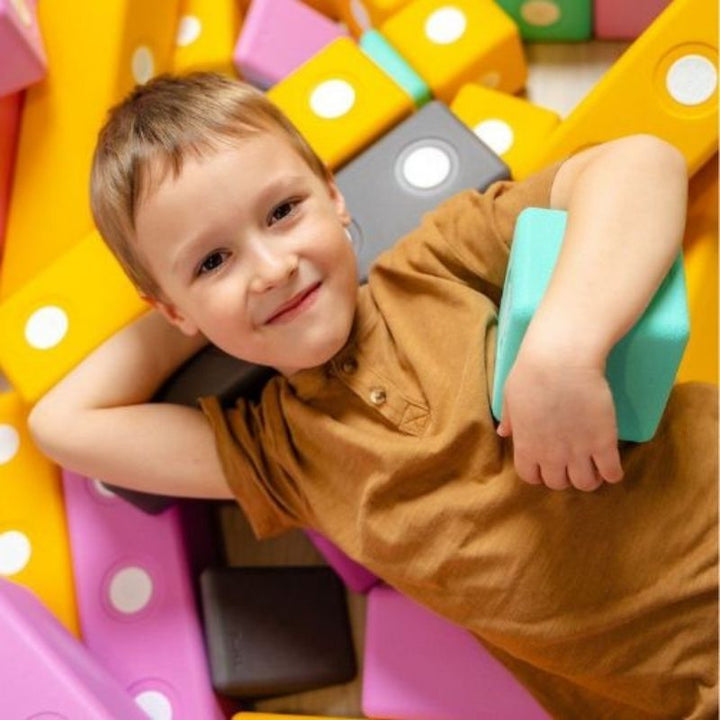 Boy actively building a floor-scale structure with the TUKI BIG Smart Magnetic Blocks Smart 100, showing the whole-body gross motor engagement and 4-Smart-shape floor construction the 100-piece group set enables