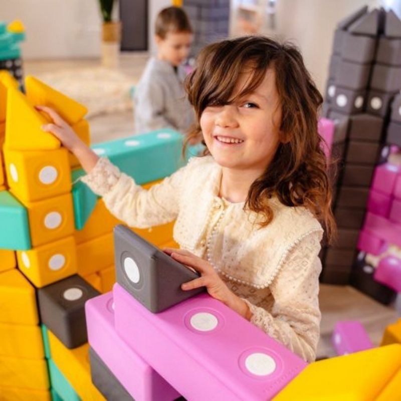 Top view of child building with the TUKI BIG Smart Magnetic Blocks Smart 100, showing the large-format 10cm group floor construction scale of the 100-piece 4-Smart-shape set for 6-9 children