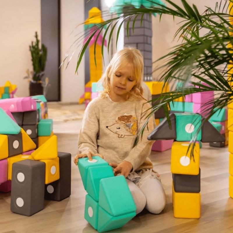 Child actively building with the TUKI BIG Smart Magnetic Blocks Smart 50, showing the large-format 10cm SMART shape floor construction the 50-piece pyramid-vocabulary group set enables for 3-5 children