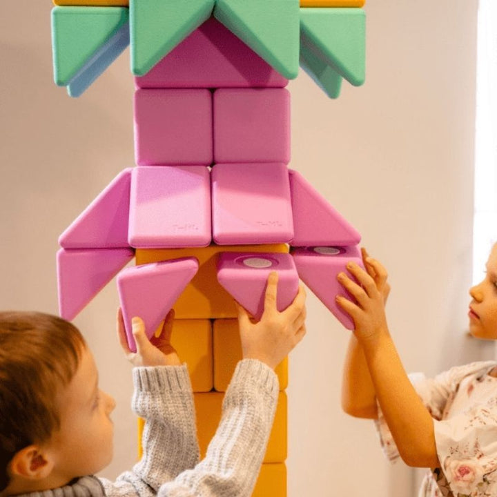 Two children building a floor-scale structure with the TUKI BIG Smart Magnetic Blocks Smart 50, demonstrating the paired and group construction the 50-piece 3 Smart shapes 4-colour set supports for 3-5 children