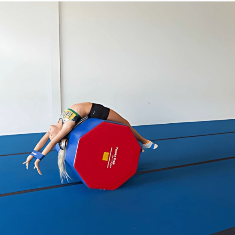 Girl performing a back bend or bridge on the Tumbl Trak Octagonal Tumbler, demonstrating the elevated surface used for flexibility training, walkovers, and back handspring skill progressions in gymnastics