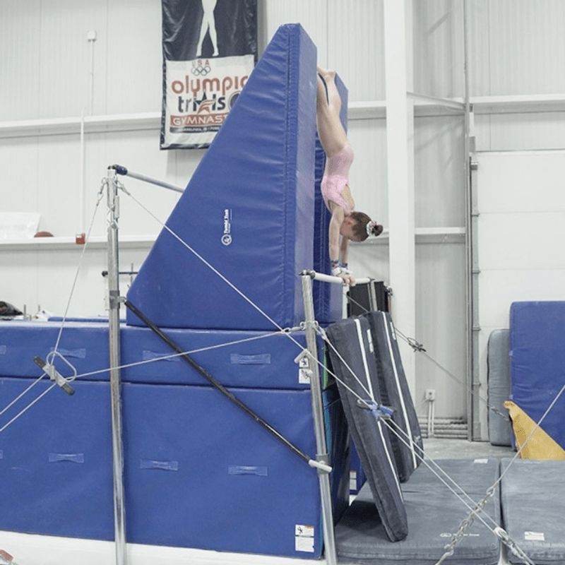 Girl performing a gymnastics routine element using the Tumbl Trak Smart Wedge, demonstrating the Al Fong-designed skill progression block in a gymnastics club training session for cast to handstand or tumbling skill development