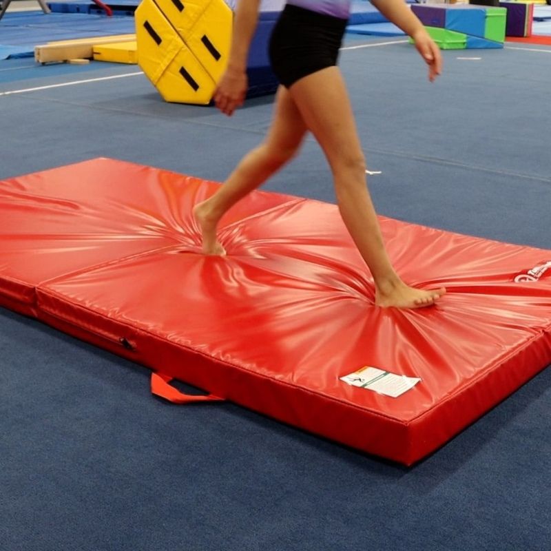Girl stepping or playing on the Tumbl Trak Soft Mat showing the mat's soft, cushioned surface used for recreational play, early childhood motor development, and occupational therapy sensory activities