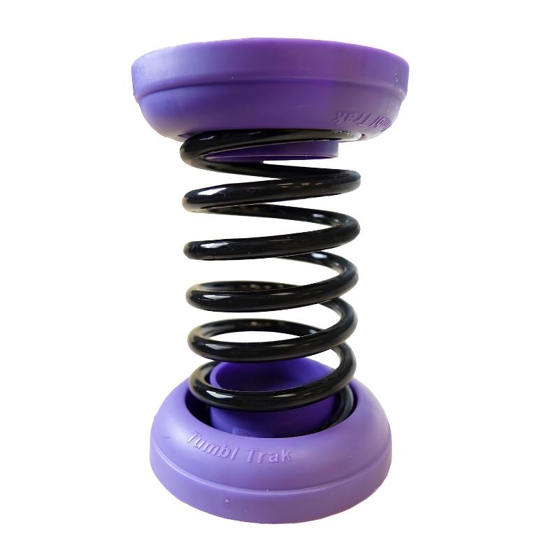 Tumbl Trak gymnastics spring floor individual spring unit showing black high-carbon steel coil with branded purple retainer caps, the core of the semi-assembled spring floor system