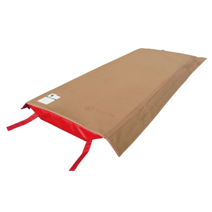 Tumbl Trak T-Trainer Cover PRO laid flat showing the tan suede vault training surface and red vinyl base with Velcro attachment straps for gymnastics gyms