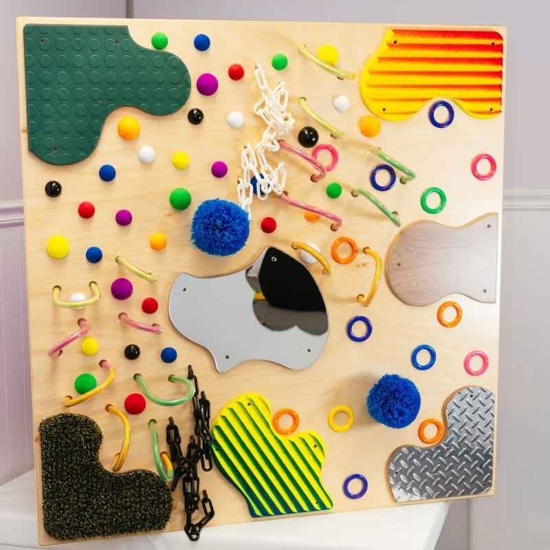 TFH UV Textured Wall shown unlit, a sensory wall panel with mirror, chains, pompoms, rings and mixed textures for tactile exploration
